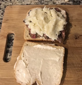 ハチミツ胚芽パンの上にマヨネーズと細切りにしたステーキとマッシュポテトを乗せてる画像