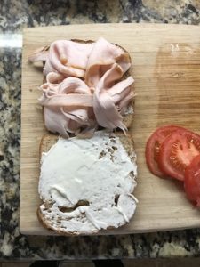 パンにマヨネーズを塗りターキーハムを乗せてる画像