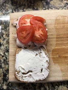 パン、ターキーの上にスライストマトを乗せた画像