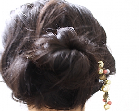 髪をアップにし、かんざしを着けた後姿の女性の画像