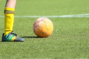 サッカーボールとサッカー選手の足の画像