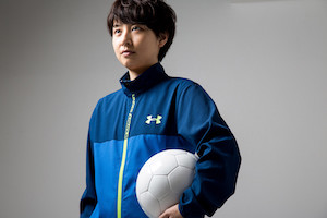 サッカーボールを脇に抱えたジャージ姿の男性の画像