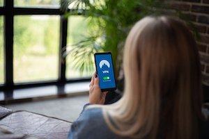 スマホの画面を見ている外国人女性をスマホの画面が見える様に後ろから写した画像