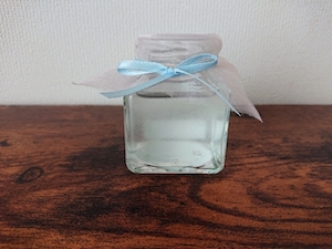 水色のリボンが付いた花瓶に薄水色の液体が入った画像