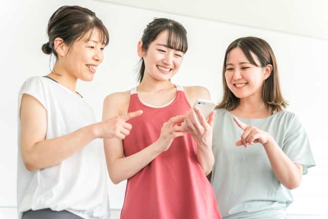 ジムでスマホを使う女性たち