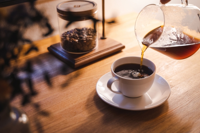 コーヒーカップにコーヒーを注いでいる画像